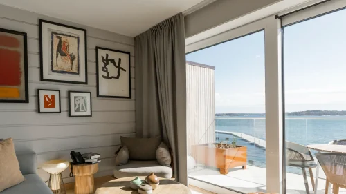 Vardagsrum i hotellsvit på Slottsholmen med stora fönster och balkong med havsutsikt.