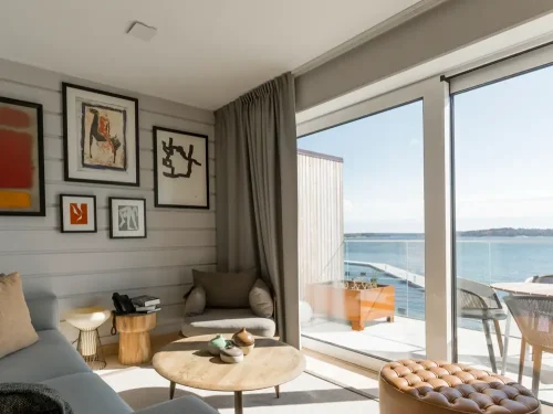 Vardagsrum i hotellsvit på Slottsholmen med stora fönster och balkong med havsutsikt.